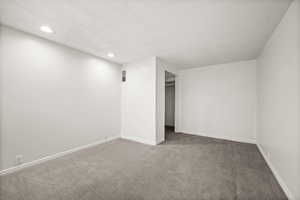 Carpeted empty room featuring a textured ceiling