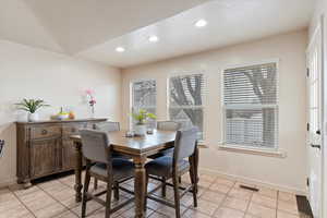 Kitchen featuring vaulted ceiling, a tile fireplace, a kitchen island, and light tile patterned floors