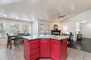 Kitchen with sink, stainless steel appliances, light stone counters, dark brown cabinetry, and decorative backsplash