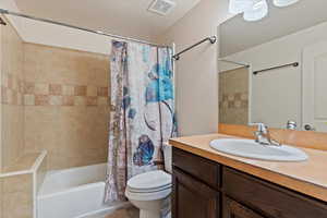 Bedroom with connected bathroom, a closet, dark hardwood / wood-style floors, and ceiling fan