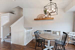 Dining area featuring dark wood-type flooring and a chandelier