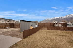 View of yard with a mountain view and a shed