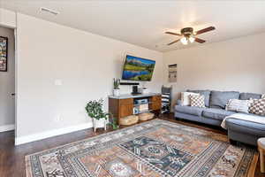 Living room featuring ceiling fan and dark hardwood / wood-style floors