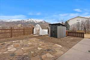 View of patio with a mountain view and a shed