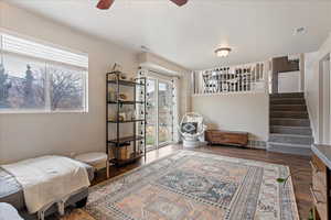 Sitting room with wood-type flooring and ceiling fan