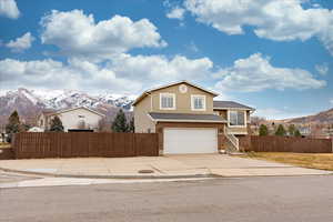 View of front of home with a mountain view and a garage