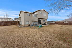 Rear view of property with a yard