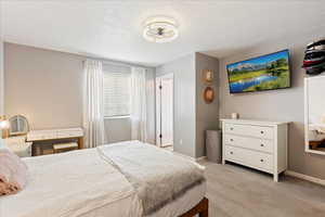 Carpeted bedroom with a textured ceiling