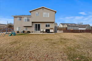 Rear view of property featuring a yard, central AC unit, and a patio area