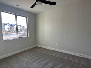 Empty room featuring ceiling fan, a textured ceiling, and carpet