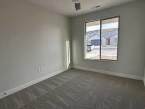 Carpeted empty room featuring ceiling fan