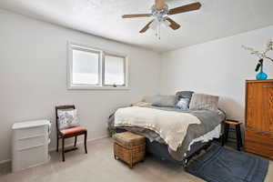 Bedroom featuring a textured ceiling, ceiling fan, light carpet, visible vents, and baseboards