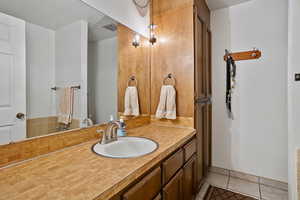 Bathroom featuring tile patterned flooring, visible vents, baseboards, and vanity