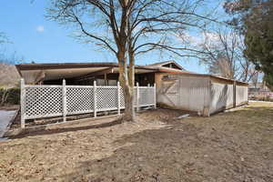 Rear view of house with an exterior structure and an outbuilding