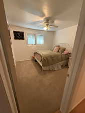 Bedroom with carpet, a textured ceiling, and ceiling fan