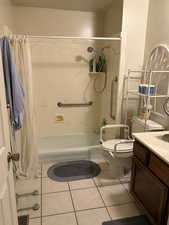 Full bathroom featuring shower / tub combo with curtain, tile patterned floors, toilet, and vanity