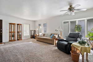 Carpeted living area with crown molding, a textured ceiling, and ceiling fan