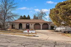 View of front facade featuring a garage, concrete driveway, and brick siding