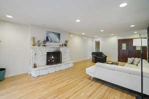 Living room featuring a stone fireplace and light hardwood / wood-style floors