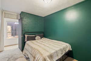 Carpeted bedroom featuring a textured ceiling