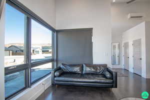 Living room featuring a high ceiling and a wall mounted AC