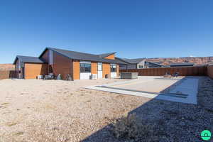 Back of house featuring a hot tub and a patio