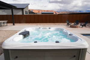 View of pool featuring a mountain view, a fire pit, a patio area, and a hot tub