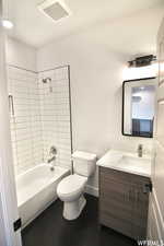 Full bathroom featuring toilet, tiled shower / bath, and vanity