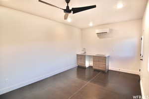 Unfurnished office featuring sink, ceiling fan, and an AC wall unit