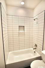 Bathroom featuring toilet and tiled shower / bath