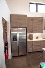 Kitchen featuring tasteful backsplash and stainless steel fridge with ice dispenser