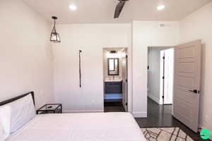 Bedroom with dark wood-type flooring and connected bathroom