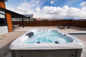 View of pool with a hot tub, a patio, and a fire pit