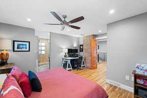 Bedroom featuring hardwood / wood-style floors, ceiling fan, and ensuite bathroom