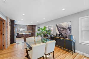 Dining space featuring sink, light hardwood / wood-style flooring, and a healthy amount of sunlight