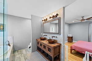 Bathroom with a tub to relax in, toilet, vanity, hardwood / wood-style floors, and backsplash