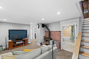 Living room featuring a wood stove and light carpet