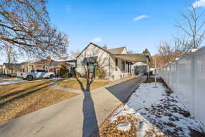 View of snowy exterior featuring a yard and a carport