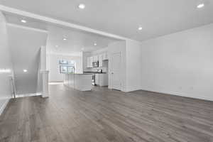 Unfurnished living room with hardwood / wood-style flooring and sink