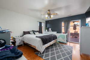 Bedroom with hardwood / wood-style floors, ceiling fan, and access to exterior