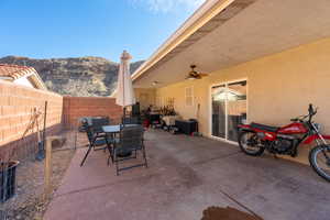 View of patio / terrace with a mountain view, electric panel, and ceiling fan