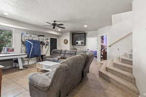 Living room featuring a textured ceiling and ceiling fan