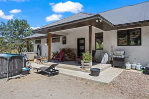 Rear view of house featuring a hot tub and a patio