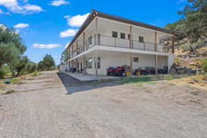 Back of house with a balcony and a patio area