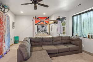 Living room featuring ceiling fan and light carpet