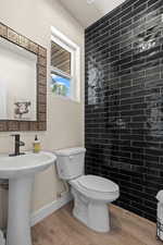 Bathroom with hardwood / wood-style flooring, toilet, and sink