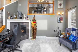 Carpeted office with a tile fireplace