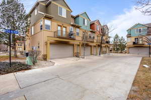 View of property with a garage and central air condition unit