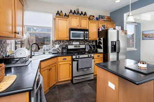 Kitchen featuring pendant lighting, stainless steel appliances, sink, and tasteful backsplash