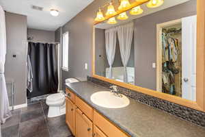 Bathroom with vanity, toilet, and tile patterned flooring